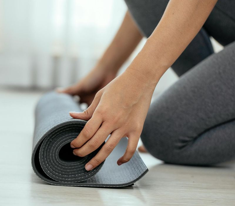 A clean, empty space with a yoga mat rolled out, ready for a workout.